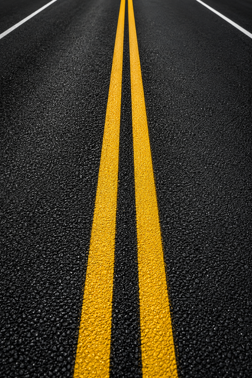 Freshly painted double-yellow centerline on asphalt highway